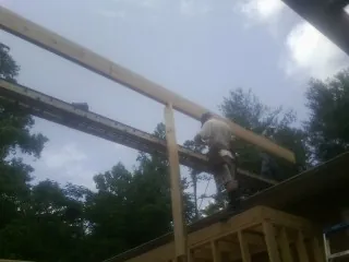 Carpenter setting a ridge beam over a new addition frame — Ice Dam Removal by Roofing Brothers in Galesburg