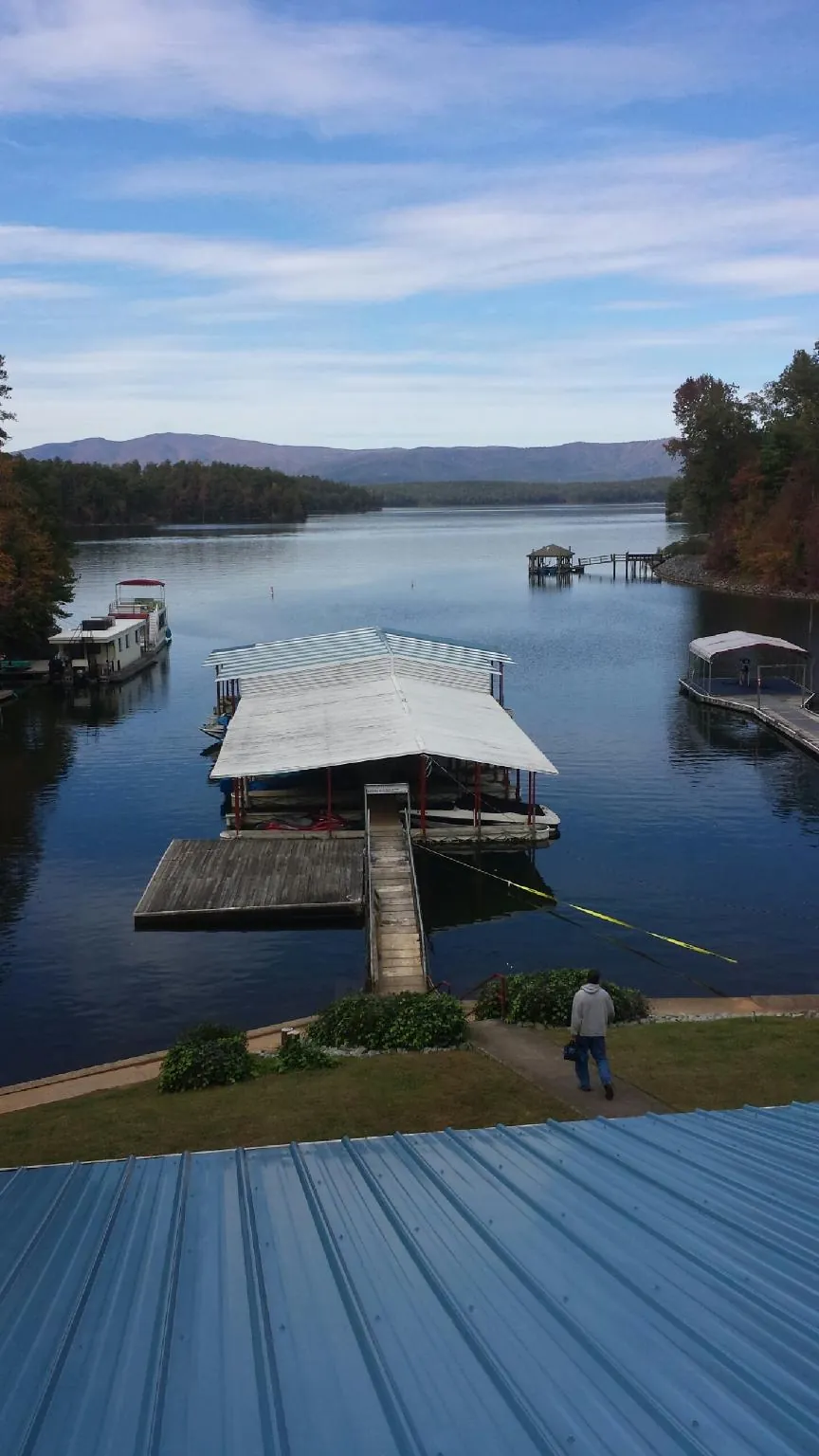 View across a lake from a newly installed blue metal roof in Galesburg