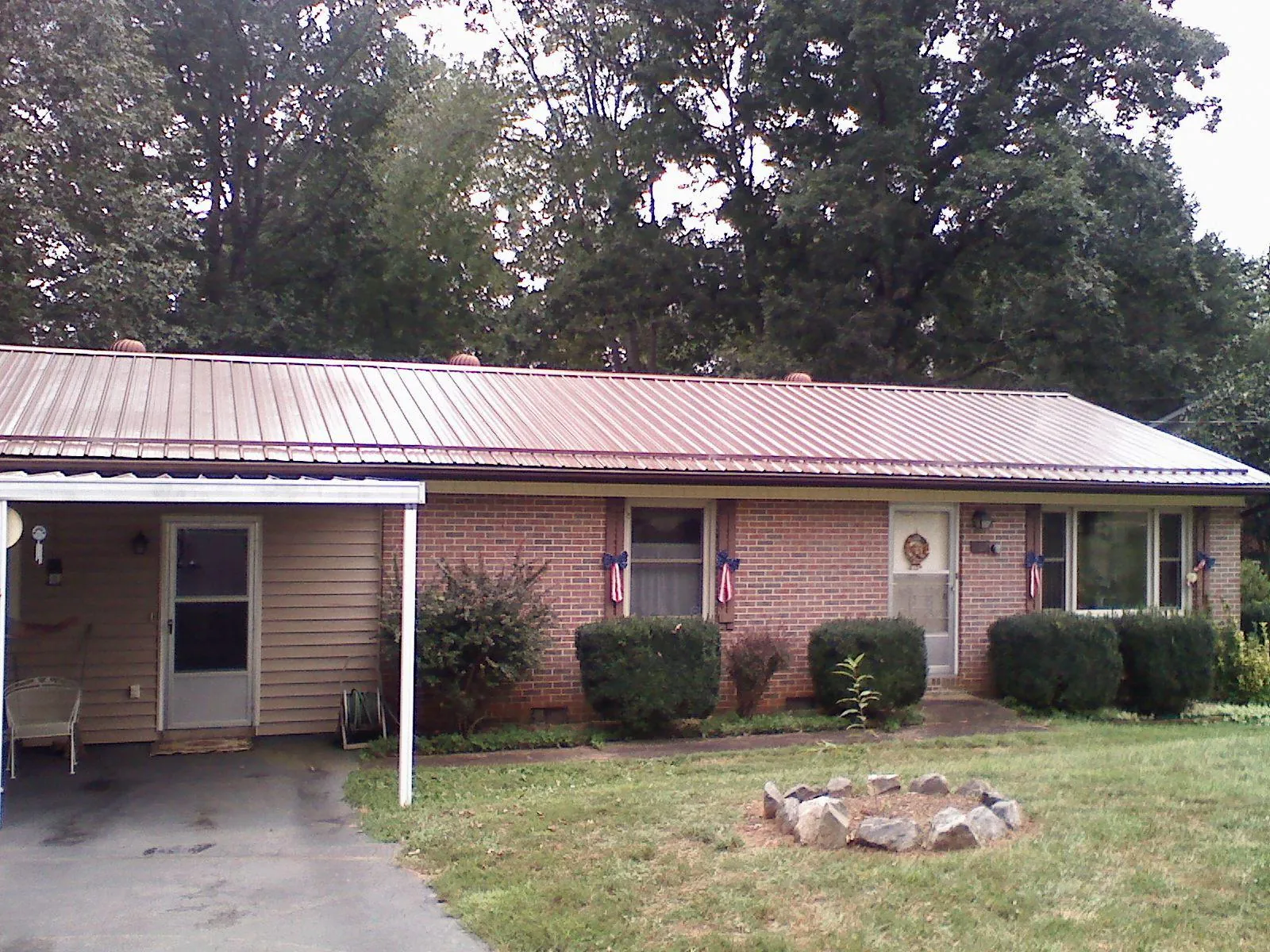 Bronze metal roof and carport on a brick ranch home — Roof Repair work by our crew in Galesburg